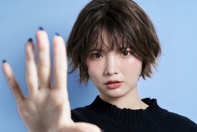 手のひらをこちらに向ける女性